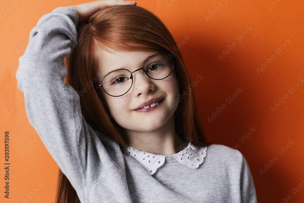 Confident kid in glasses with long, red hair Confident kid in glasses with long, red hair