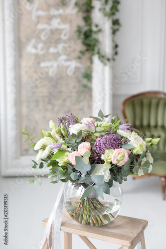 Beautiful luxury bouquet of mixed flowers in glass vase. the work of the proffesional florist at a flower shop.