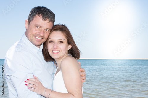 Romantic couple standing on the beach and enjoying beautiful sea view