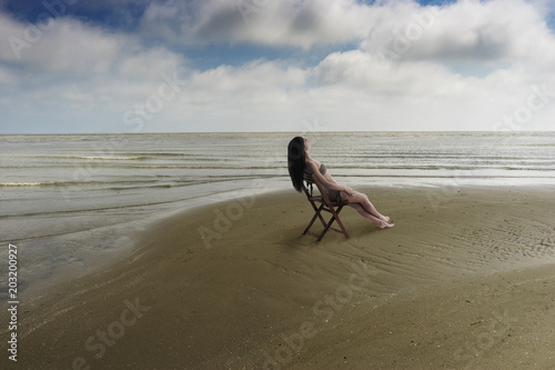 young woman sitting on a solitary beach