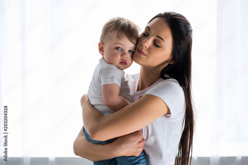 portrait of tender mother holding cute baby in hands at home portrait of tender mother holding cute baby in hands at home