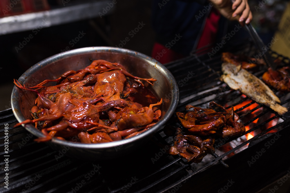 Chicken prepared for grill in Cambodian night street food market 