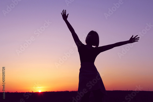 People,Freedom,Travel,Abstract Concept.Silhouette Of A Young Woman Holding Hands In The Air At Sunset,Cropped Shot.Shot Of A Carefree Woman At The Beach Against The Sunset.Goodbye Sunlight.Hello!
