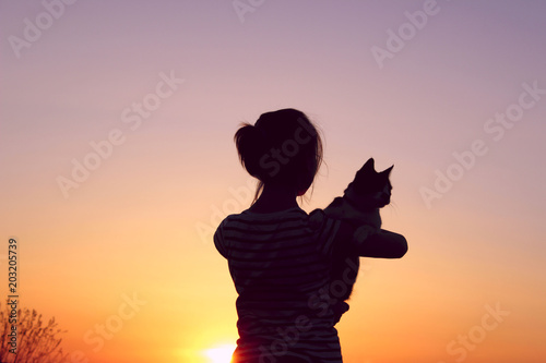 People Freedom Pet  Travel Abstract Concept.Silhouette Of A Young Girl Holding A Cat At Sunset Cropped Shot.Shot Of A Carefree Girl At The Beach Against The Sunset.Goodbye Sunlight.  