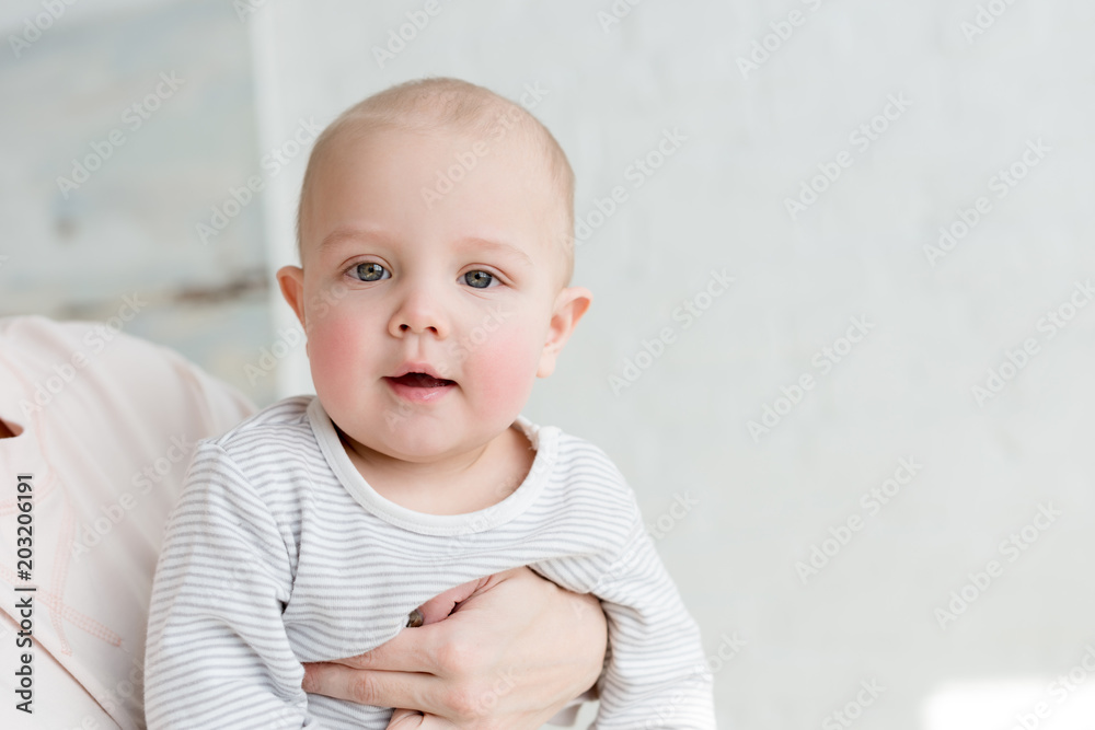 little happy son on mothers hands looking at camera little happy son on mothers hands looking at camera