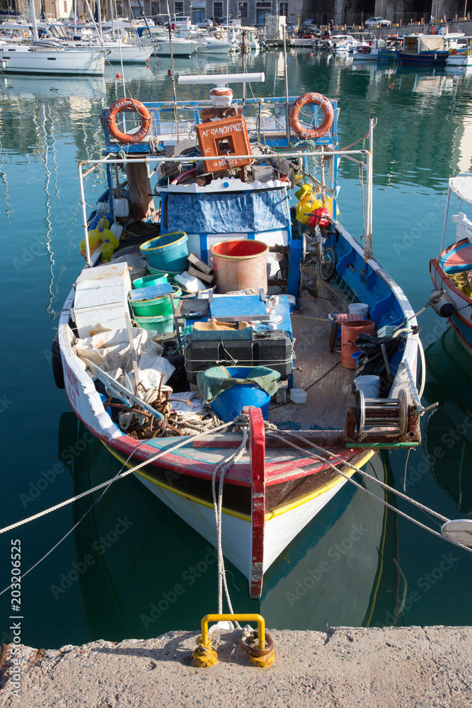 Voll beladenes buntes Fischerboot vertäut in einem Hafen in Kreta