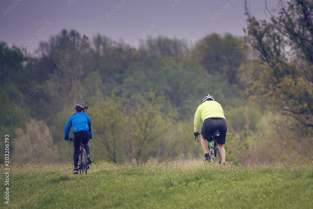 Fototapeta premium woman and man riding bicycles in the natural environment