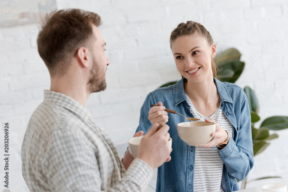 young couple eating corn flakes for breakfast in morning young couple eating corn flakes for breakfast in morning