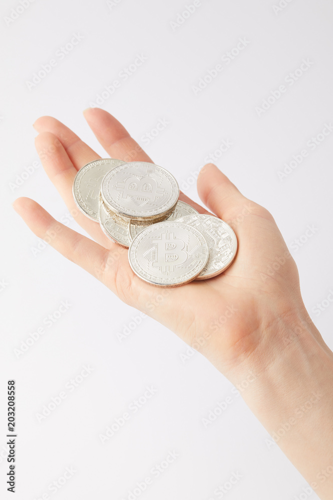 Fototapeta premium cropped shot of woman holding pile of bitcoins isolated on white