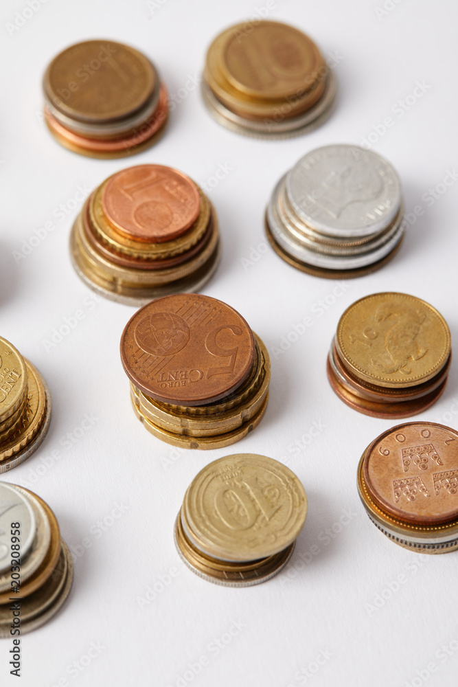 close-up shot of stacks of different coins on white close-up shot of stacks of different coins on white