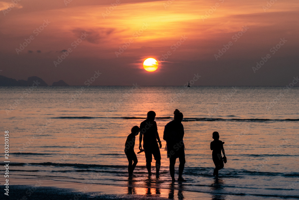 Fototapeta premium Sonnenuntergang im Meer mit Familie (Silhouette)