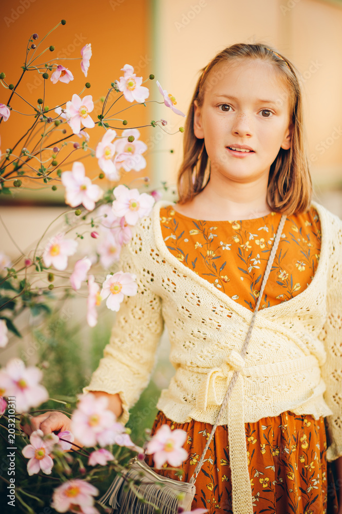 Outdoor fashion portrait of cute preteen girl, wearing brown dress and yellow knitted jacket Outdoor fashion portrait of cute preteen girl, wearing brown dress and yellow knitted jacket