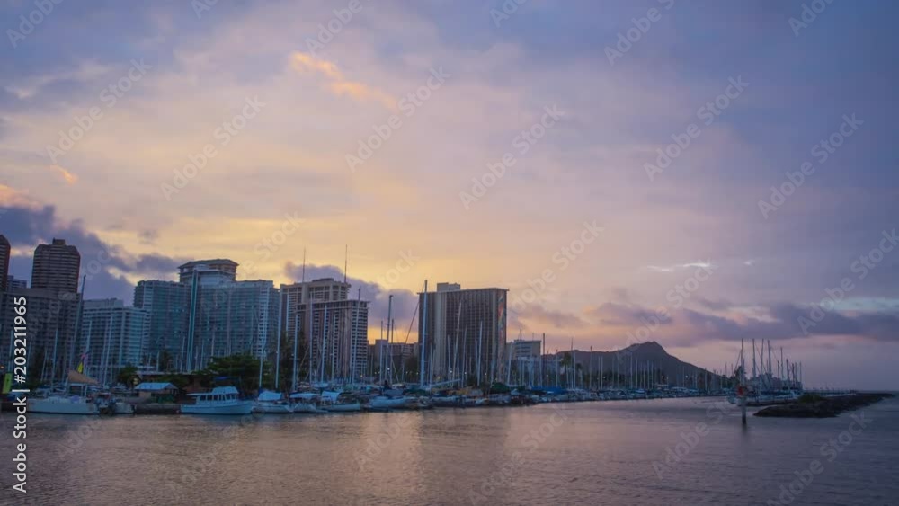 Time lapse in motion ( hyper lapse ) first rays of sun illuminating cityscape and beaches of Waikiki and Honolulu in Oahu, Hawaii Time lapse in motion ( hyper lapse ) first rays of sun illuminating cityscape and beaches of Waikiki and Honolulu in Oahu, Hawaii