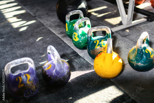 Sport equipment in gym. Kettlebell on floor background with sunlight effect. Fitness training. photo
