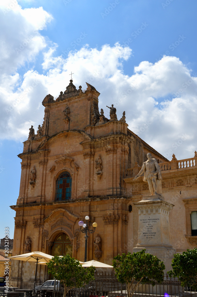 View of Busacca Statue and in the Background the Carmine Church, Scicli, Ragusa, Sicily, Italy, Europe, World Heritage Site View of Busacca Statue and in the Background the Carmine Church, Scicli, Ragusa, Sicily, Italy, Europe, World Heritage Site