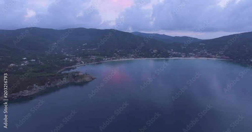 Aerial, island coast with beautiful calm sea in the evening and overcast sky Aerial, island coast with beautiful calm sea in the evening and overcast sky