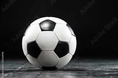 A round black and white football ball on black background