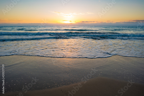  sunset or sunrise on the sea with a sandy beach. Calm sea at dusk