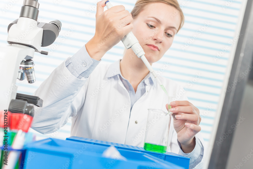 Experiments in the chemical laboratory, Female researcher using her test tube in a laboratory Experiments in the chemical laboratory, Female researcher using her test tube in a laboratory