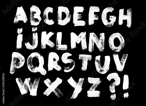 Alphabet set of white capital handwritten letters on a black background. Drawn by semi-dry brush with unpainted areas.