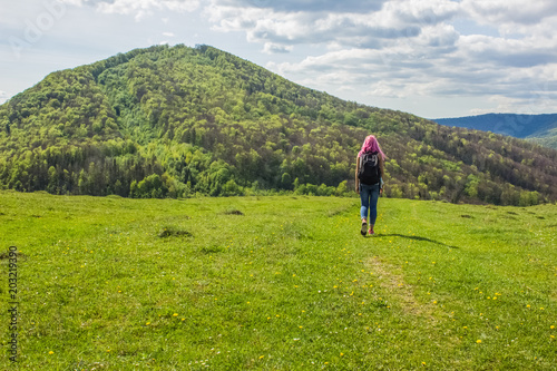 soft focus backpack travel girl with pink hair back to camera on beautiful nature forest mountain landscape