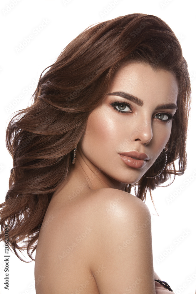Fototapeta premium Beauty portrait of a young girl with natural make-up and natural lip color. Hairstyle curls, chestnut hair color. White isolated background.