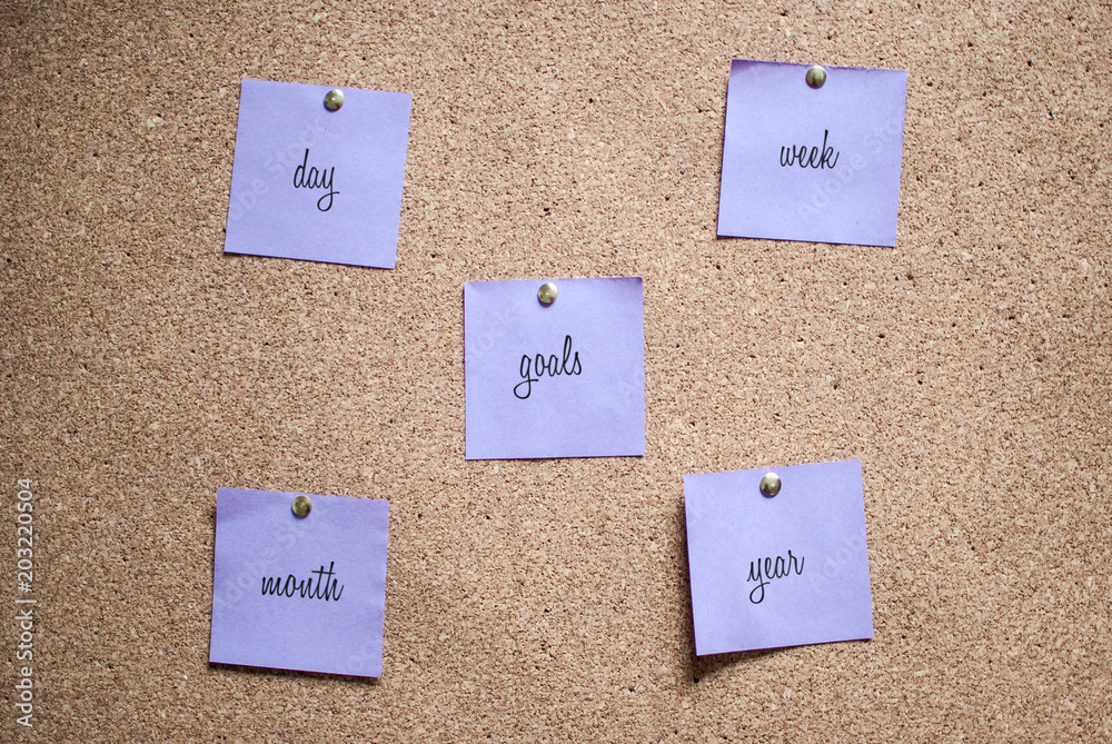 Multiple notes (stickers) with handwritten words on a cork board. Multiple notes (stickers) with handwritten words on a cork board.