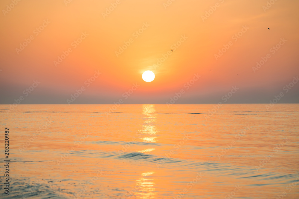 Sunset or sunrise over sea with sun on beautiful dramatic sky