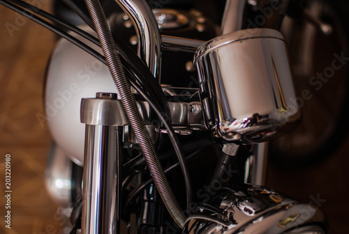 Closeup of chopper's chrome handlebar, fork, and actuator © Yurii Zymovin