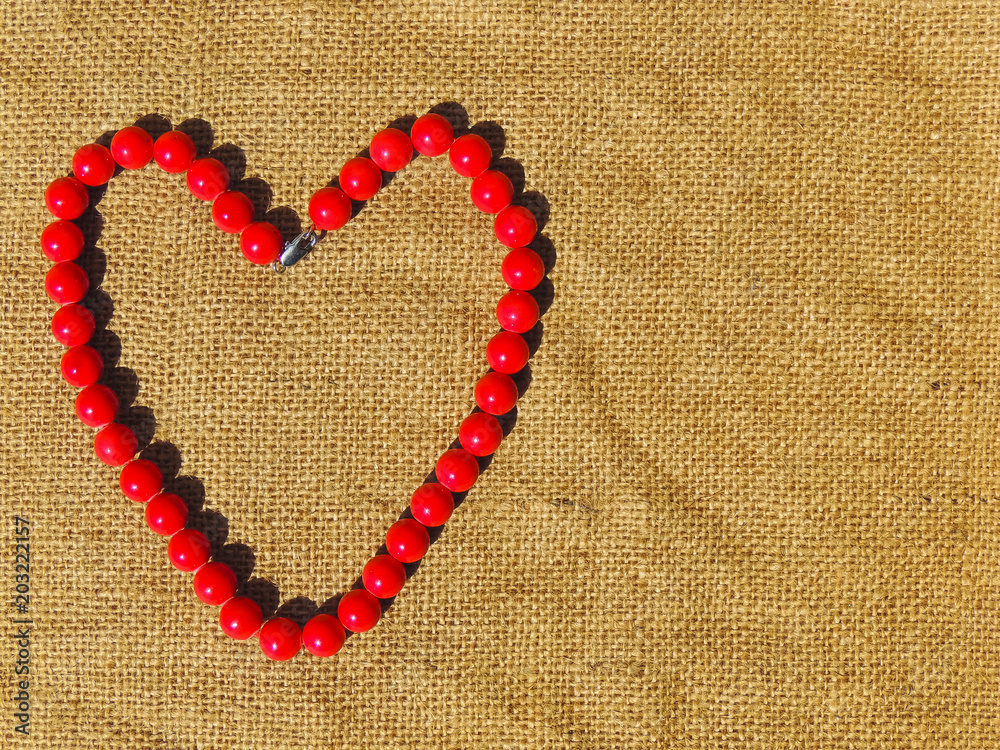 heart made of beads on a burlap background