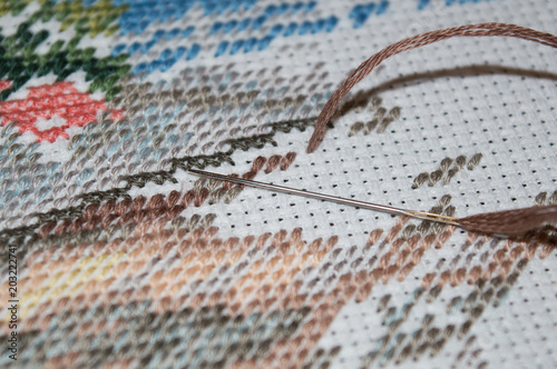 Принти на полотні Cross stitch embroidery process with brown cotton thread in the needle