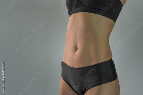 Beautiful sports female body on a gray background