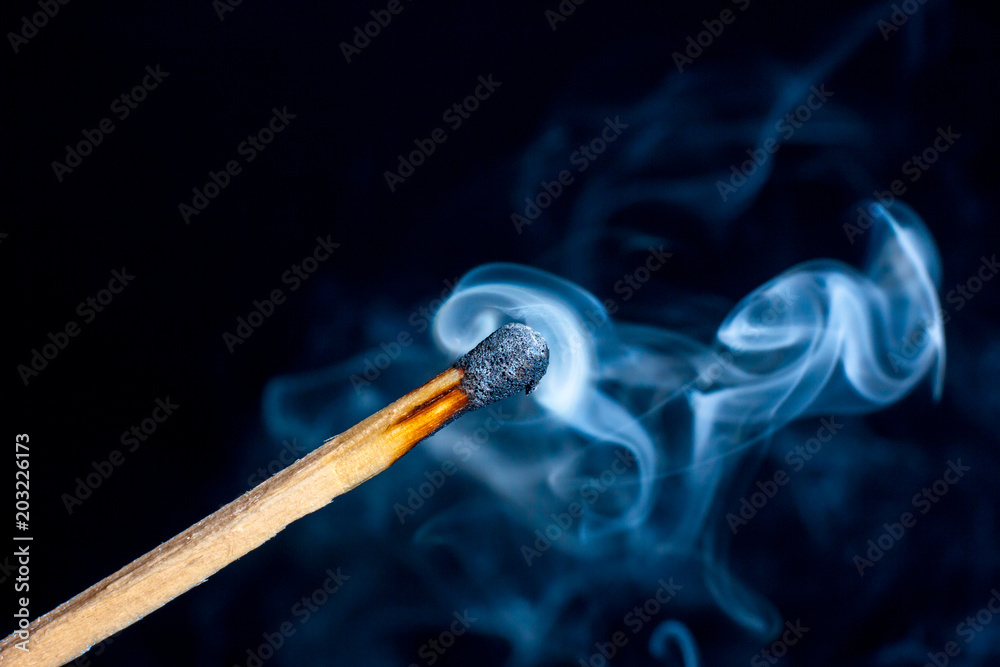 Burning match isolated on black background