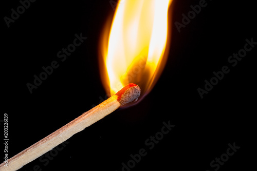 Burning match isolated on black background