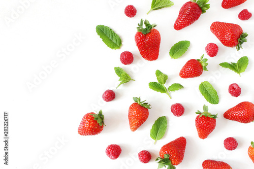 Styled stock photo. Summer healthy fruit composition with red strawberries, raspberries, fresh green mint leaves isolated on white table background. Food pattern. Empty space. Flat lay, top view.
