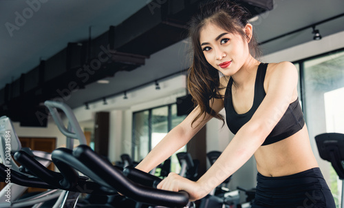 Female woman lifestyle using equipment machine exercise bike for training cardio workout