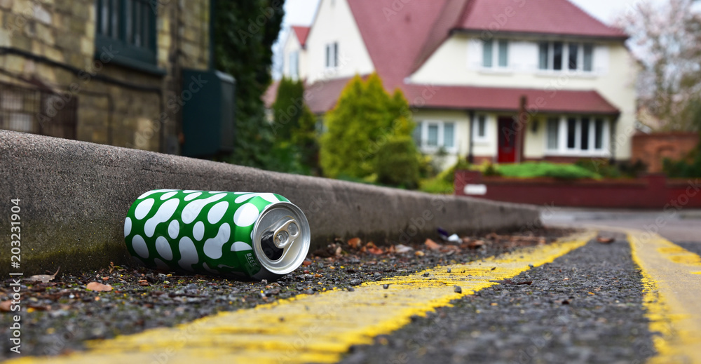 Obraz premium Discarded drinks can lying at the edge of an urban street
