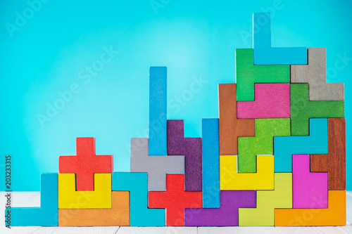 Fotografie Different colorful shapes wooden blocks on blue background