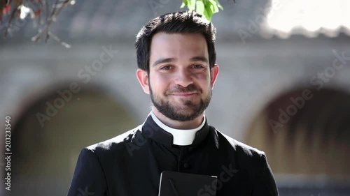 close up portrait of happy serene young priest outdoor