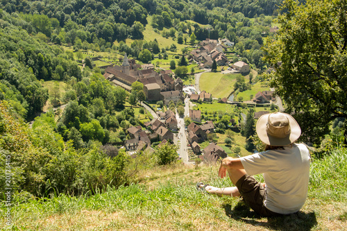 Une personne seule comptemple un village du haut de la colline. 