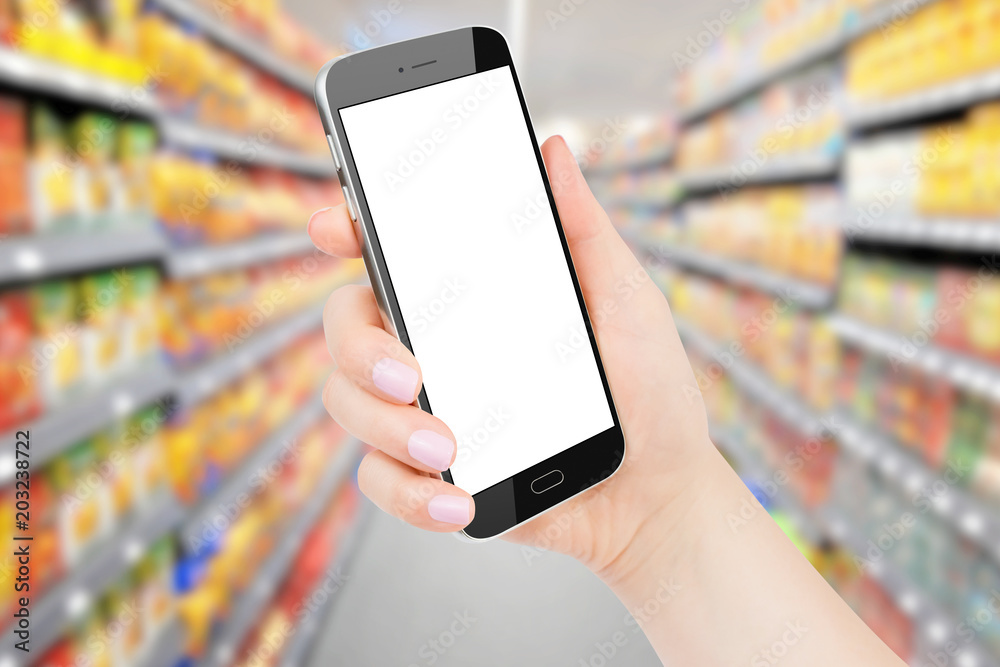 Female hand holding black phone with isolated screen, blurred grocery store in background. Online shopping concept, Mockup Female hand holding black phone with isolated screen, blurred grocery store in background. Online shopping concept, Mockup