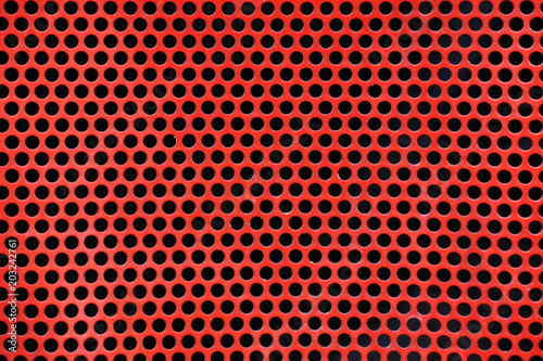 Red metal background with round holes.