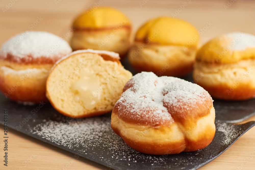 sweet donut sprinkled with powdered sugar on a plate closeup