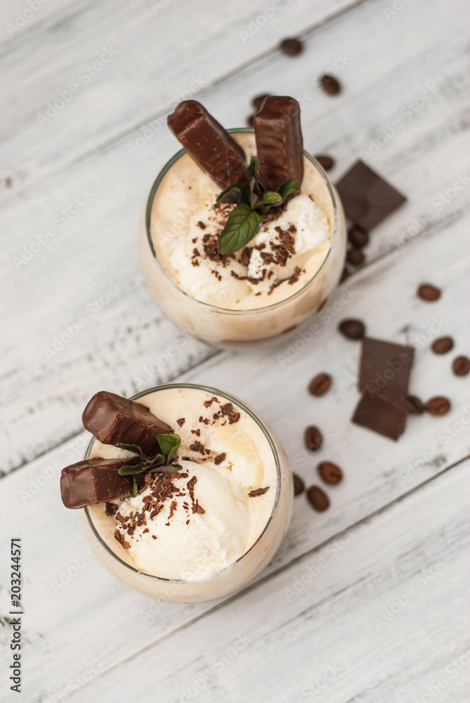 Iced Mocha Frappe Coffee with Whip Cream, Summer Drinking times. Coffee Beans. rustic textured Wooden Background. Mint Leaves Iced Mocha Frappe Coffee with Whip Cream, Summer Drinking times. Coffee Beans. rustic textured Wooden Background. Mint Leaves