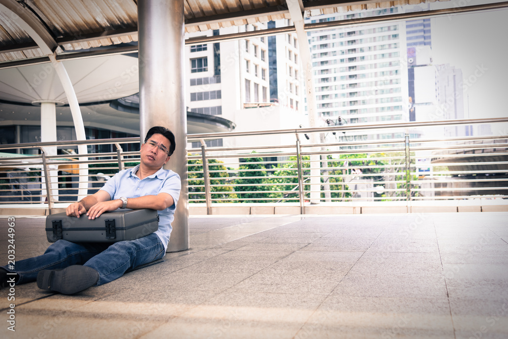 Adisn business man sitting in depression with black bag. Adisn business man sitting in depression with black bag.