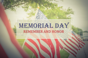 Text Memorial Day and Honor on long row of lawn American Flags background. Green grass yard USA flags blow in the wind. Concept of Memorial day or Veteran's day in America.