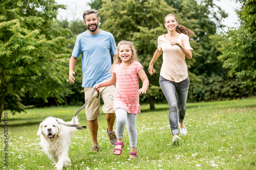 Girl and parents with Golden Retriever