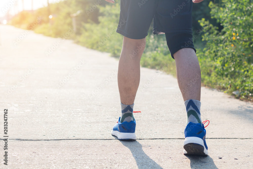 Young asian athlete man tying running shoes in front house,male runner ready for jogging on the road outside,wellness and sport concepts