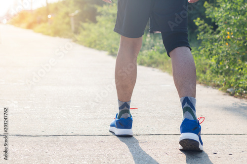 Young asian athlete man tying running shoes in front house,male runner ready for jogging on the road outside,wellness and sport concepts