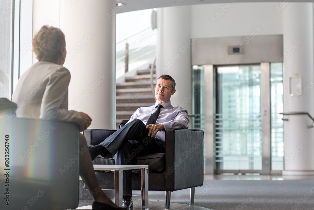 Businessman and businesswoman discussing with each other in office Businessman and businesswoman discussing with each other in office